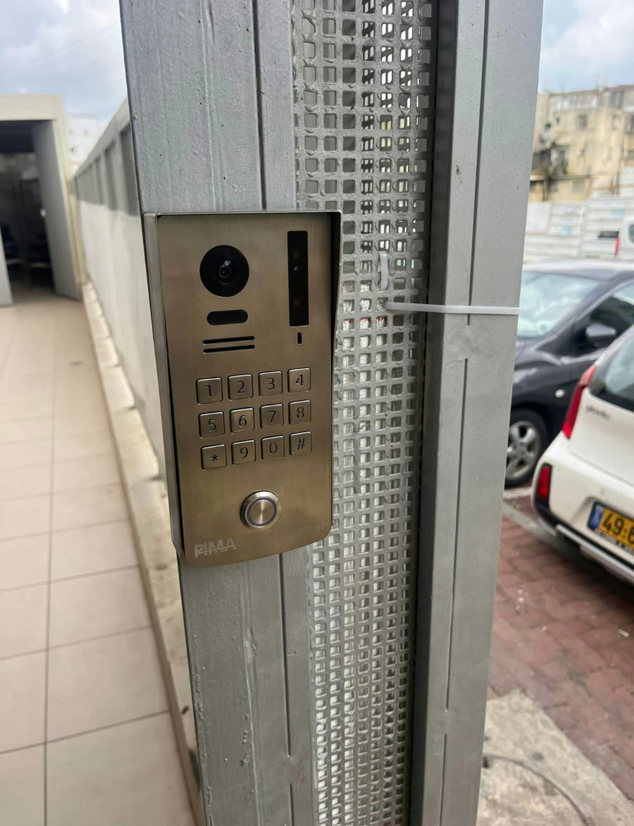אינטרקום עם מקלדת על עמוד מתכת בכניסה לחניון